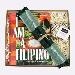 Gift box featuring the Filipino cookbook "I Am a Filipino" by Nicole Ponseca, 2 green woven placemats, and an Ilocano salt
